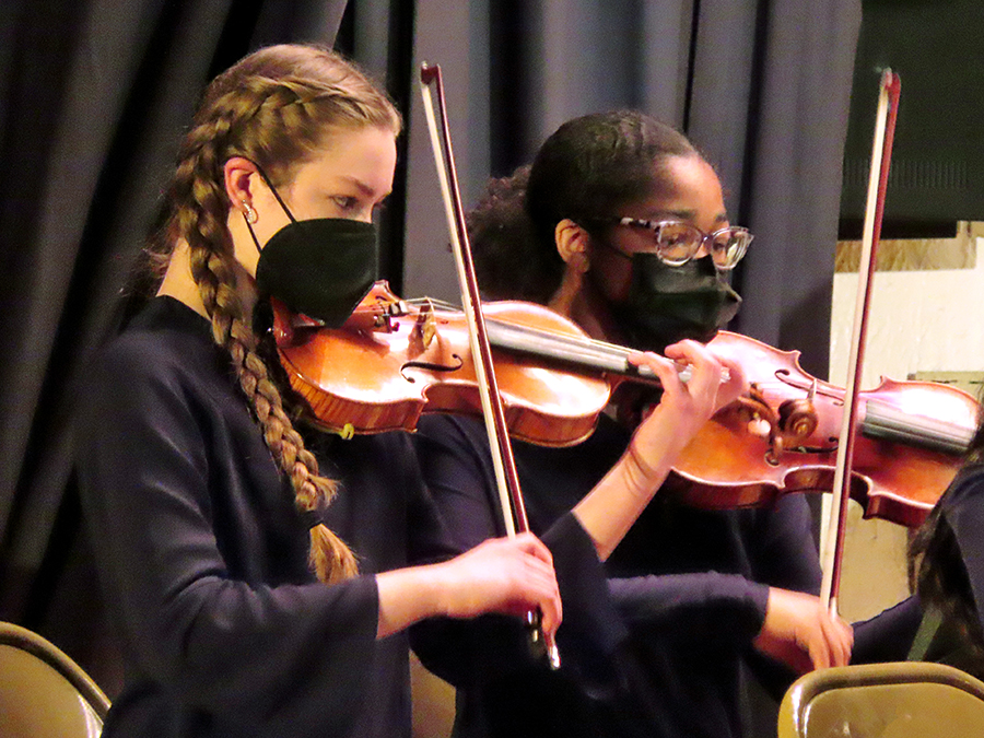 Two Accelerando Strings violinists playing on stage.
